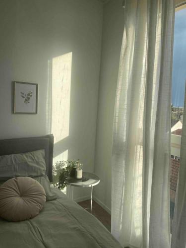um quarto com uma cama e uma janela com vista em Le Petit Paradis Parisien em Montmagny