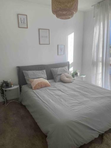 un grand lit avec deux oreillers dessus dans une chambre dans l'établissement Le Petit Paradis Parisien, à Montmagny