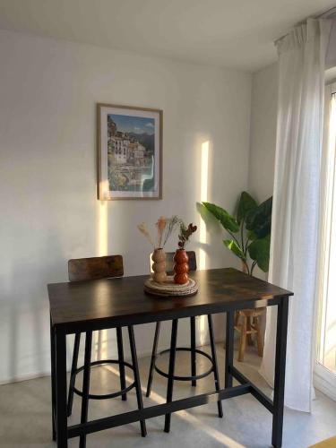 uma mesa de jantar com duas cadeiras num quarto em Le Petit Paradis Parisien em Montmagny