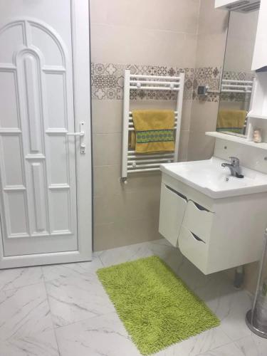 a bathroom with a sink and a shower with a mirror at Résidence Le Figuier Marako, Tizi-Gheniff in Tizi Gheniff