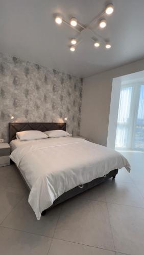 1 dormitorio con 1 cama grande con sábanas blancas en VIP Апартаменти подобово, en Lutsk