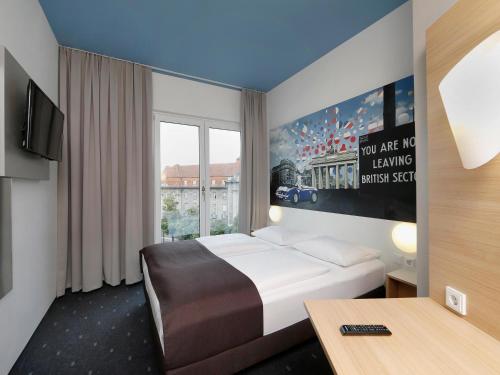 ein Hotelzimmer mit einem Bett und einem großen Fenster in der Unterkunft B&B Hotel Berlin-Charlottenburg in Berlin