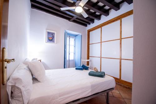 a white bed in a room with a window at Apartamento Santa Maria Life in Cádiz
