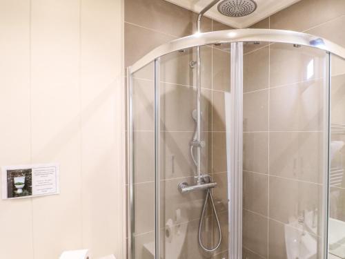 a shower with a glass door in a bathroom at Barrowden in Cottesmore