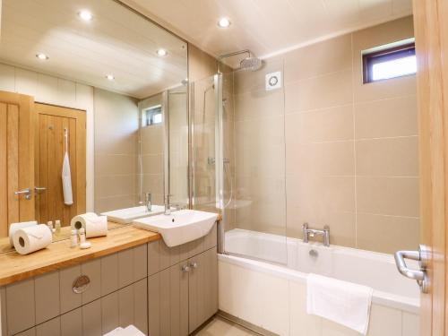 ein Badezimmer mit einem Waschbecken, einer Badewanne und einem Spiegel in der Unterkunft Brooke in Cottesmore