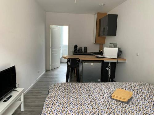 Cet appartement comprend une chambre avec un lit et une cuisine avec un comptoir. dans l'établissement Studio en centre ville d'Argentan, à Argentan