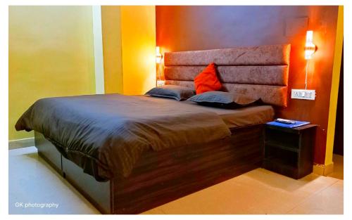 a bedroom with a large bed with two pillows on it at K & K Hotel in Jabalpur