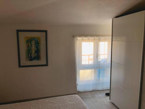 una stanza con finestra e un dipinto sul muro di Luis Apartment - Appartamento per single o coppia R7265 a Nuoro
