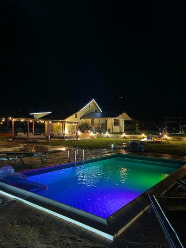 a swimming pool lit up at night at Complex Brădișor in Malaia