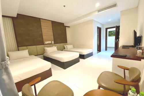 a hotel room with two beds and a desk at LCS Hotel & Apartment in Phnom Penh