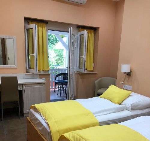 a bedroom with two beds and a desk and a sink at Szem-s Vendégház in Balatonszemes