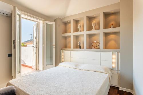 - une chambre avec un grand lit blanc et une fenêtre dans l'établissement Terrazza Napoleone - Affitti Brevi Italia, à Lucques
