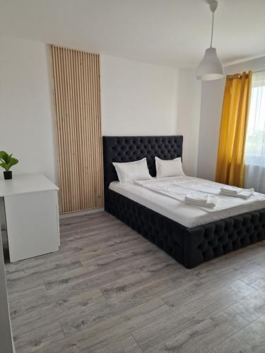 een slaapkamer met een groot bed met een zwart hoofdeinde bij Luxury Grey Apartments in Iaşi