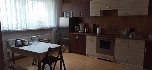 a kitchen with a table and a refrigerator at Pokój blisko centrum in Bielsko-Biała