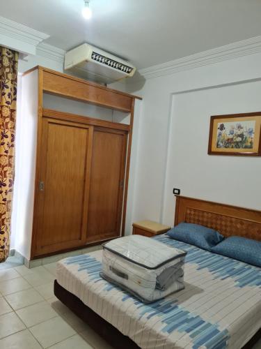 a bedroom with a bed with a suitcase on it at Amazing flat in Gardenia plaza in Sharm El Sheikh