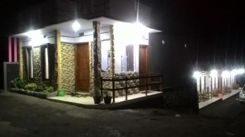 a house lit up at night with lights at Mentigen Homestay in Ngadisari