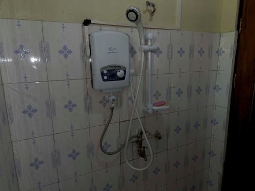 a bathroom with a shower with a soap dispenser on the wall at Olive Palm Suites Jinja in Jinja