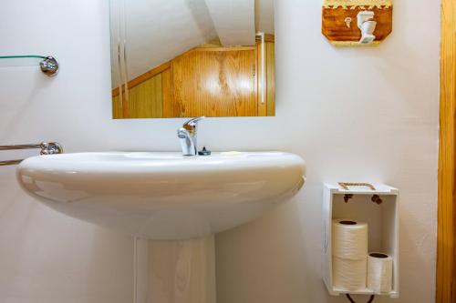 lavabo blanco en el baño con espejo en A Casa da Rapariga de Cabelo Azul, en Manteigas