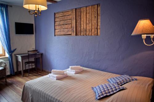 a bedroom with a bed and a table and a lamp at Pilsberģu krogs in Jūrkalne
