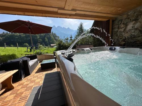 a hot tub with a water feature with an umbrella at Chalet Brünig in Meiringen
