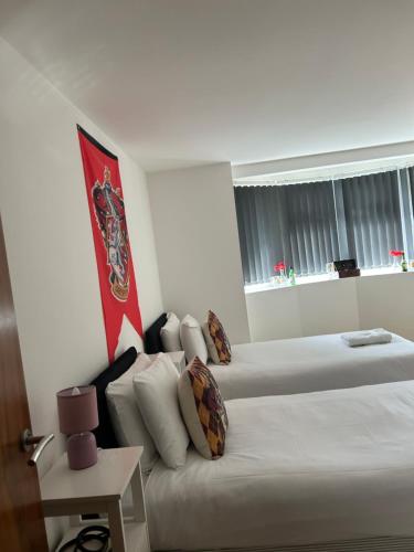 um quarto de hotel com duas camas e um sofá em Spinners End em Watford