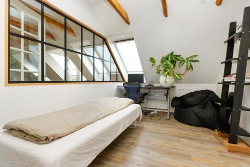 a bedroom with a bed and a desk and a window at Come Stay in Penthouse With Room For 2-People in Aarhus