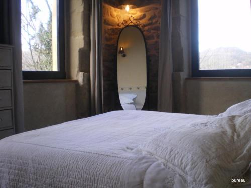 a bedroom with a white bed and a mirror at Petit Gite De La Renaissante in Peyrins