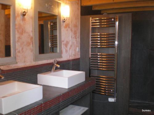 a bathroom with two sinks and two mirrors at Petit Gite De La Renaissante in Peyrins
