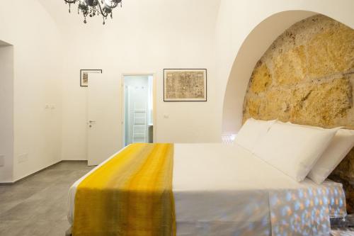 ein Schlafzimmer mit einem großen Bett und einer Steinmauer in der Unterkunft Casanica1 in Palermo