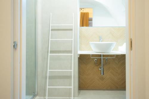 ein Badezimmer mit einem weißen Waschbecken und einem Spiegel in der Unterkunft Casanica1 in Palermo
