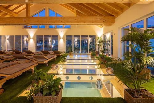 ein Hallenbad mit Tischen und Stühlen in einem Gebäude in der Unterkunft Mosel Village Resort in Ellenz-Poltersdorf