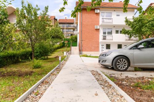 a car parked on a sidewalk next to a building at Sunflower Apartmani in Soko Banja