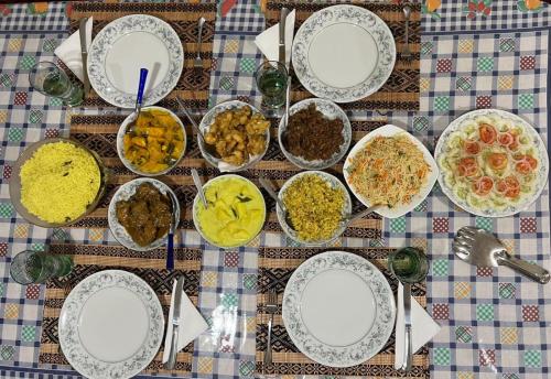 a table with many plates of food on it at Keshiya Holiday Home in Nuwara Eliya
