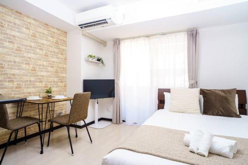 a bedroom with a bed and a table with chairs at Green Sea Oshiage 5F in Tokyo