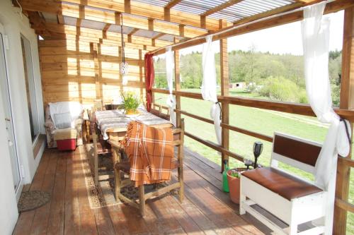 a screened in porch with a table and chairs on it at Przystan Ramotowo in Lidzbark Warmiński