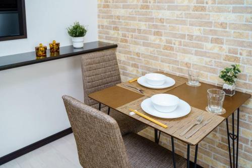 a wooden table with two chairs and a brick wall at Green Sea Oshiage 5F in Tokyo