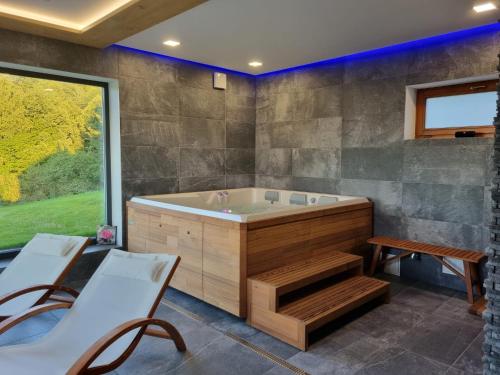 a bathroom with a tub and a table and chairs at Penzion Stříbrník in Krásná
