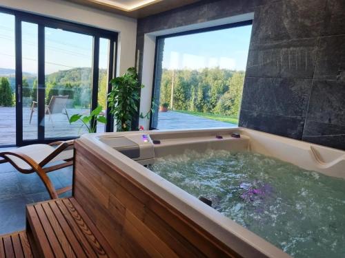 a hot tub in a house with a large window at Penzion Stříbrník in Krásná