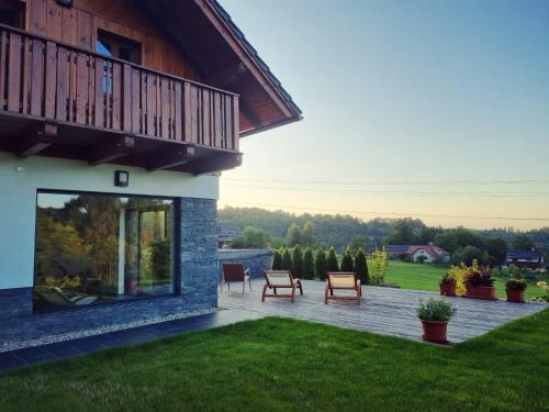 a patio with two chairs and a building at Penzion Stříbrník in Krásná