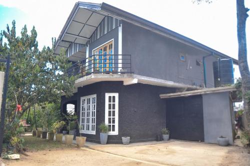 a blue house with a balcony on top of it at Mount Elegance in Nuwara Eliya