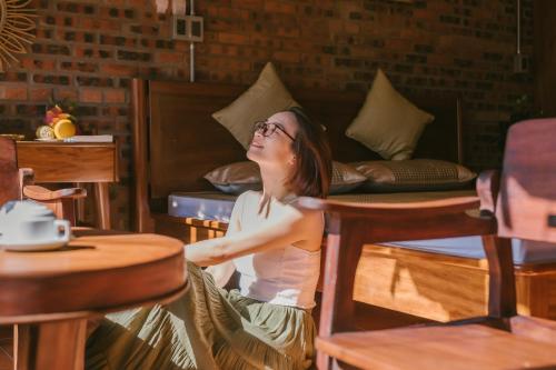 a woman sitting at a table in a room at Faifo Retreat Villa Hội An in An Bang