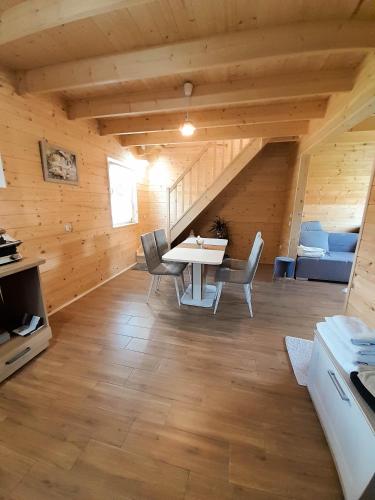 a dining room with a table and chairs in a cabin at Słodki Zakątek Spa Jacuzzi&Sauna in Sobolów