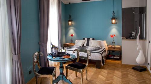 ローマにあるQT Suites Romaのベッドルーム1室(ベッド1台、テーブル、椅子付)