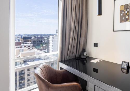 a room with a chair and a large window at Duxton Hotel Perth in Perth