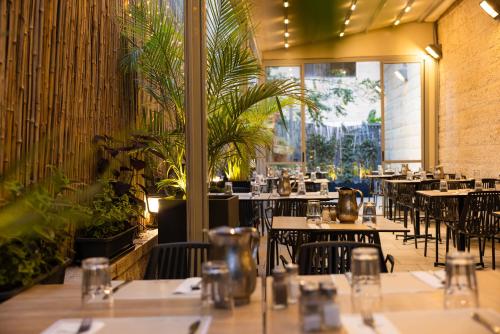 a restaurant with tables and chairs and plants at Caesar Premier Jerusalem Hotel in Jerusalem
