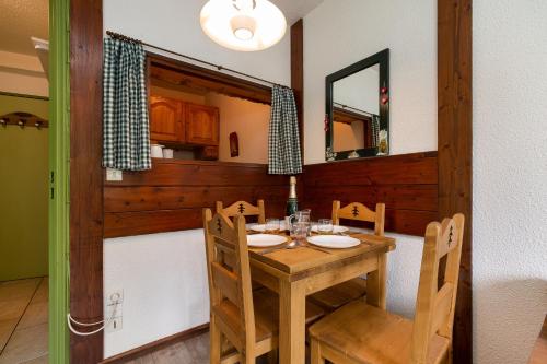 une salle à manger avec une table et des chaises en bois dans l'établissement Chamonix Sud - Jonquilles 38 - Happy Rentals, à Chamonix-Mont-Blanc