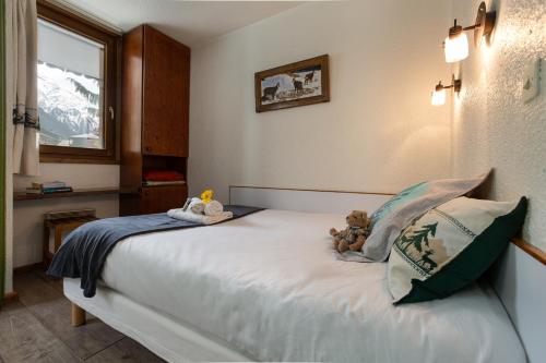 a bedroom with a bed with a teddy bear on it at Chamonix Sud - Jonquilles 38 - Happy Rentals in Chamonix-Mont-Blanc