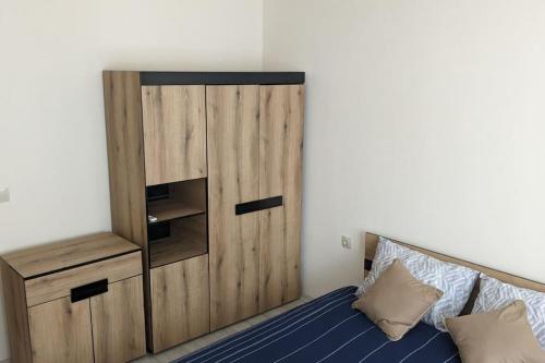 a bedroom with a wooden cabinet and a bed at Сарафово Център in Burgas City