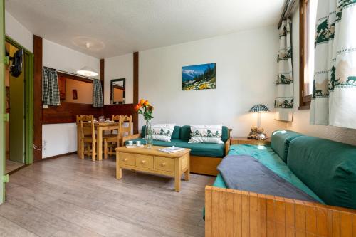 un salon avec un canapé vert et une table dans l'établissement Chamonix Sud - Jonquilles 38 - Happy Rentals, à Chamonix-Mont-Blanc