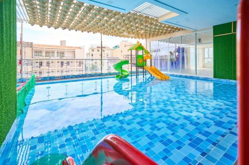 a swimming pool with a slide in a building at Vung Tau Palm Homestay 1 - Gold Sea in Vung Tau